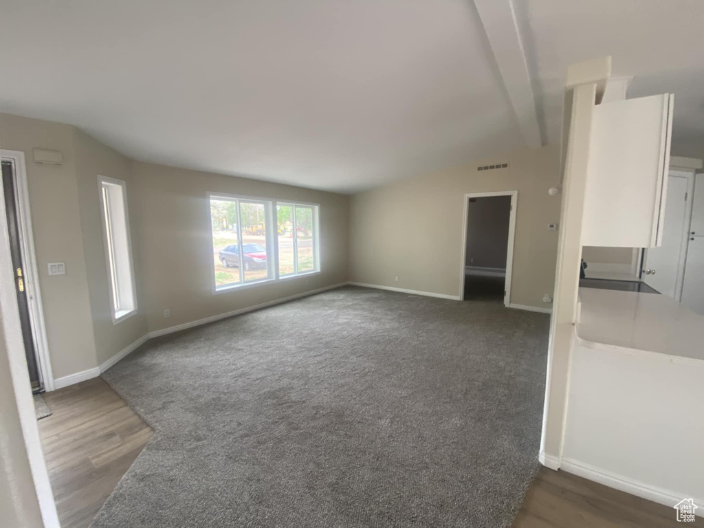 Empty room featuring baseboards and dark wood finished floors