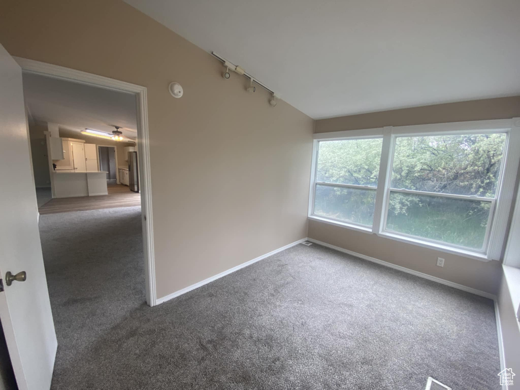 Unfurnished room with track lighting, carpet flooring, and baseboards