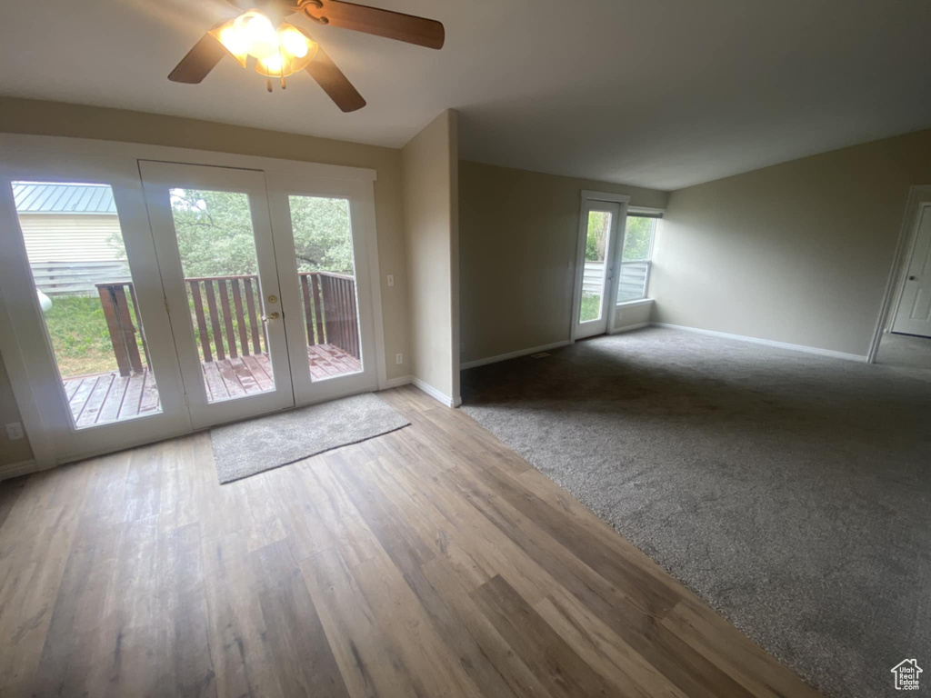 Empty room featuring french doors, baseboards, a ceiling fan, and wood finished floors