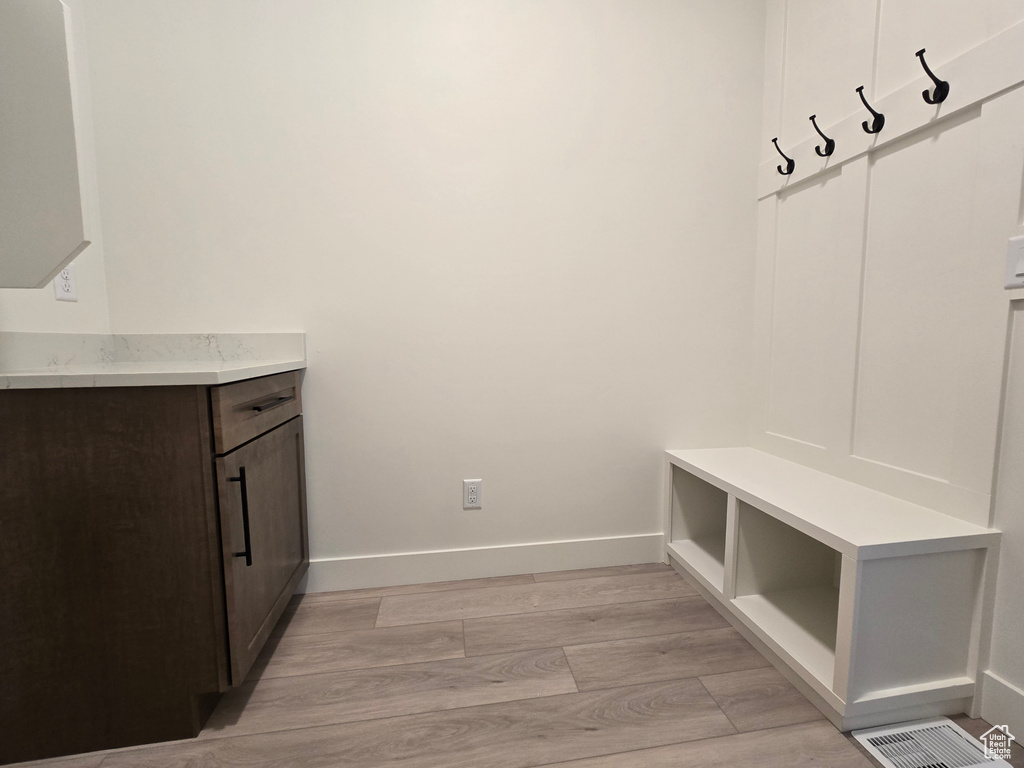 Mudroom featuring light wood-style floors and baseboards