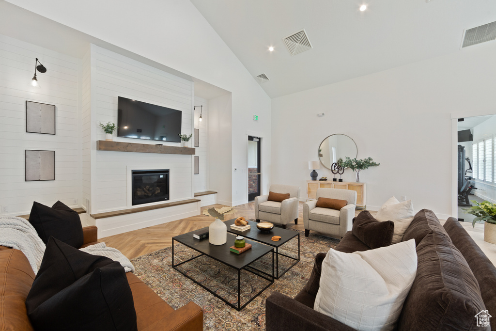 Living area with high vaulted ceiling, a fireplace, baseboards, and recessed lighting