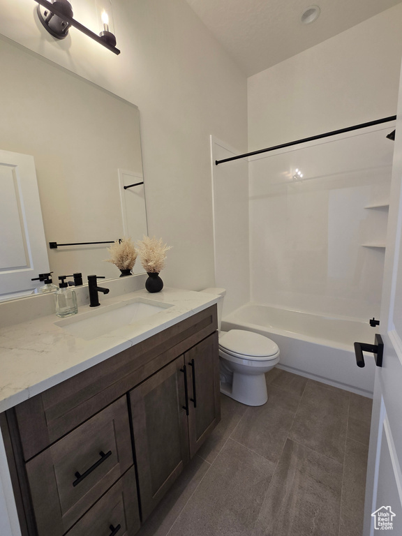 Full bath featuring toilet, vanity, tile patterned flooring, and bathtub / shower combination