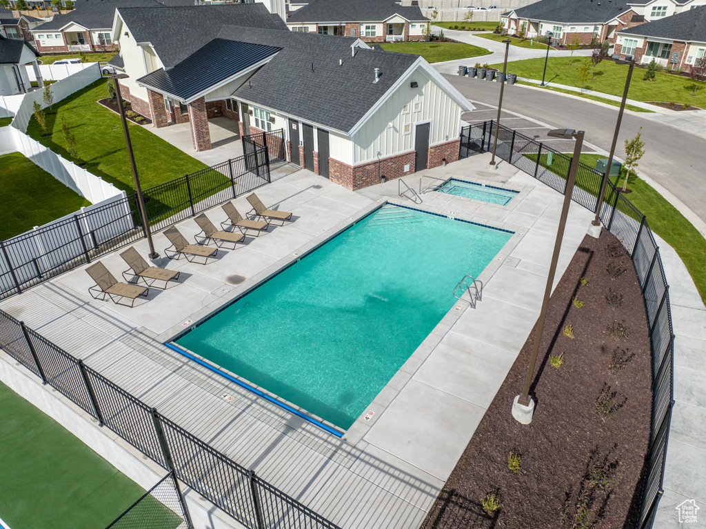 Community pool featuring a residential view, a patio, and a hot tub