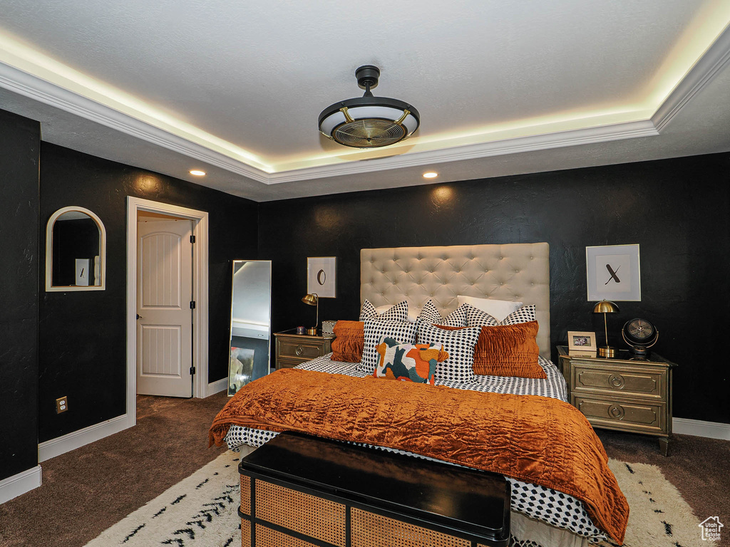 Bedroom with a raised ceiling, carpet floors, and baseboards