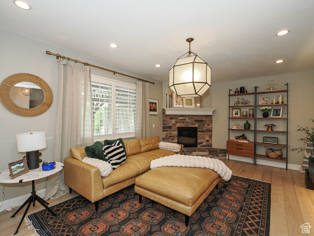 Living area featuring a fireplace, light wood finished floors, recessed lighting, and baseboards