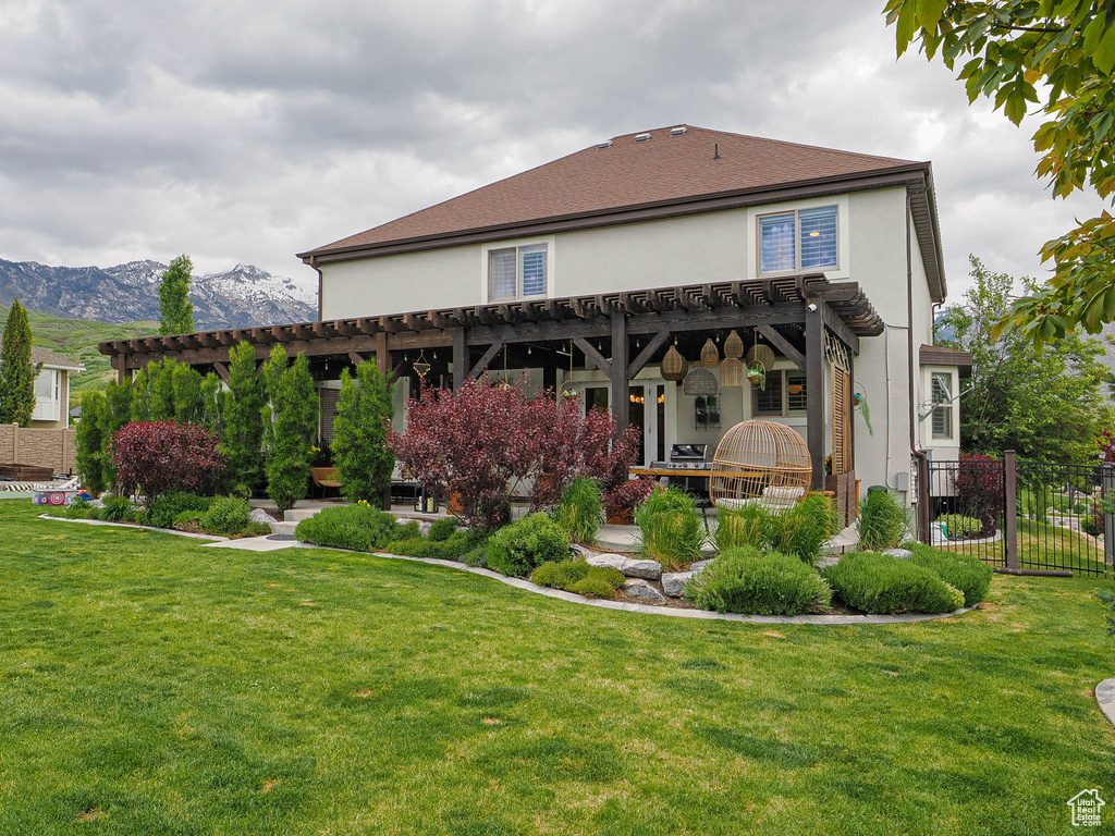 Back of property with a pergola, stucco siding, and a mountain view