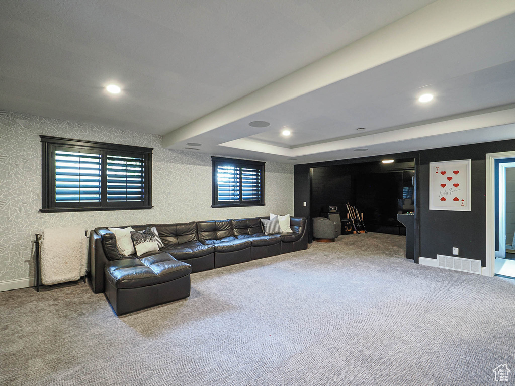 Living room with carpet floors, recessed lighting, and a tray ceiling