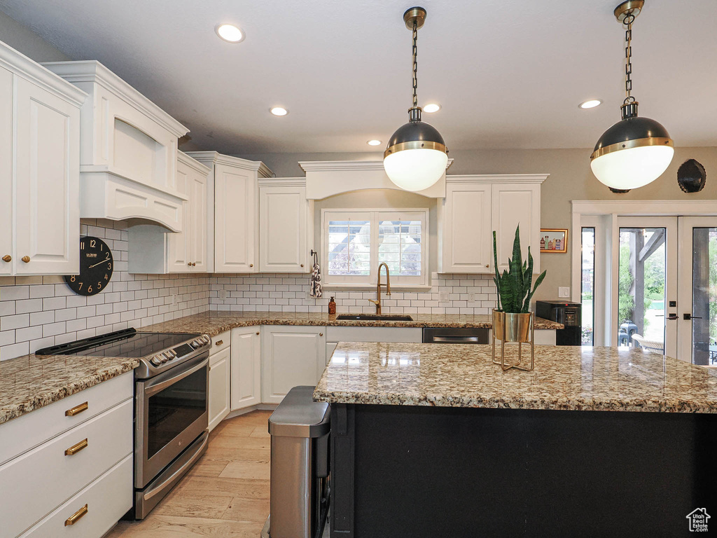 Kitchen featuring stainless steel range with electric cooktop, a sink, healthy amount of natural light, recessed lighting, and light wood-style floors