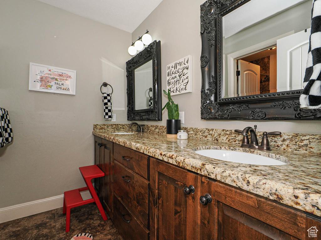Full bath featuring baseboards and double vanity