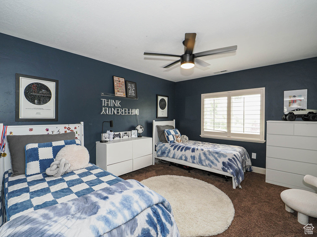 Carpeted bedroom featuring a ceiling fan and baseboards