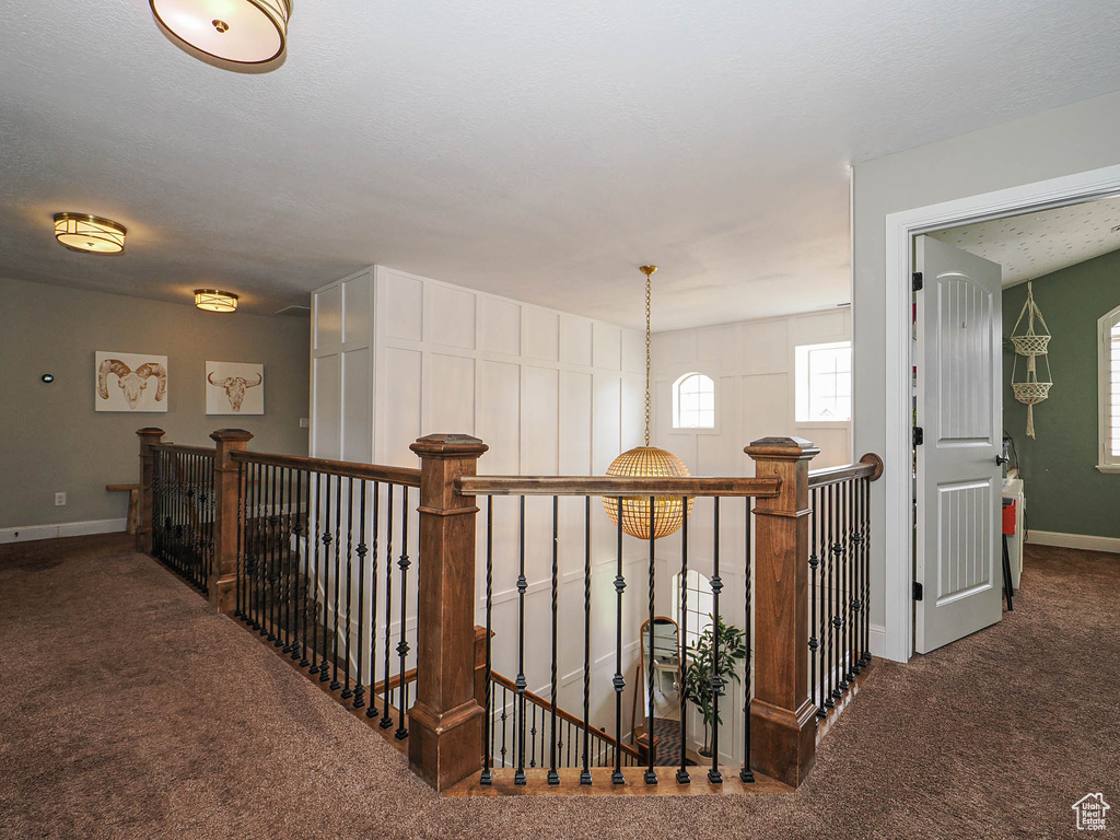 Hall featuring an upstairs landing, carpet flooring, and baseboards