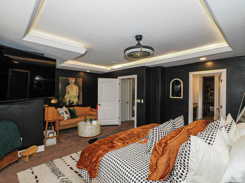 Carpeted bedroom featuring a tray ceiling