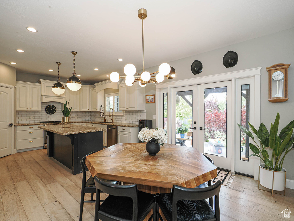 Dining area featuring light wood-style flooring, french doors, recessed lighting, and a chandelier