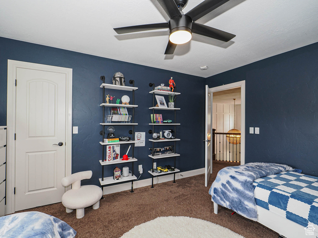 Carpeted bedroom featuring ceiling fan