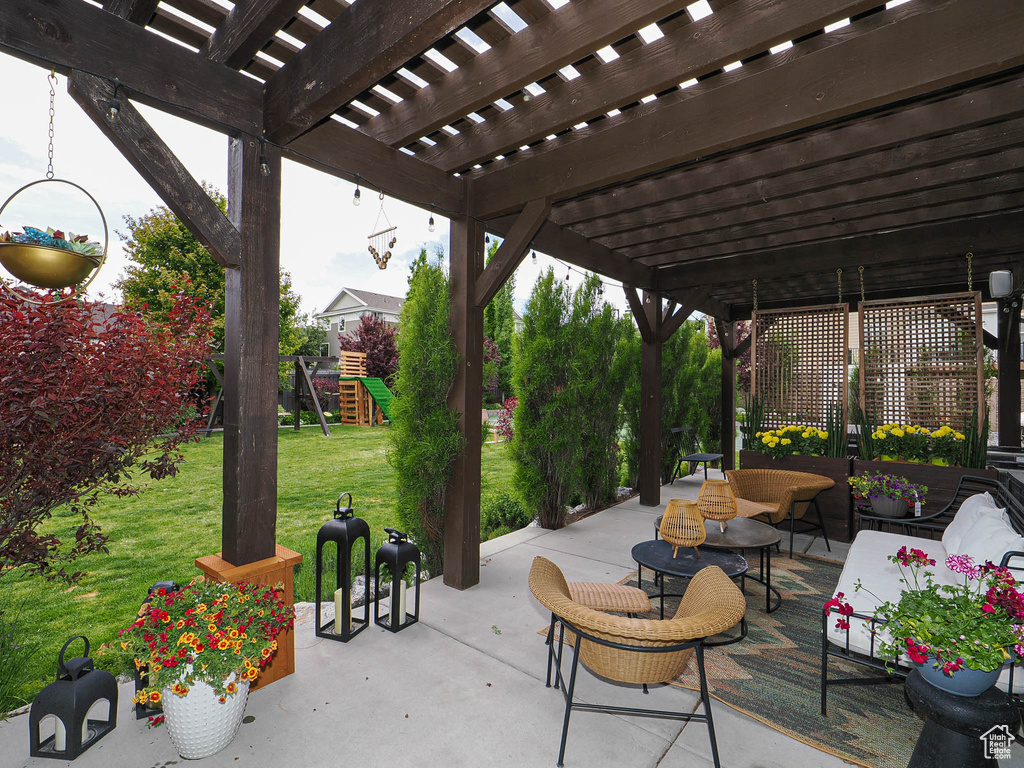 View of patio with a playground, a pergola, and an outdoor hangout area