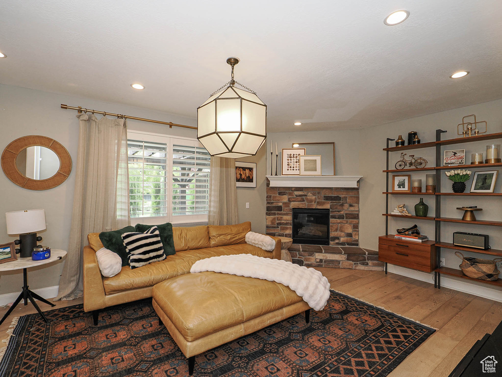 Living room with hardwood / wood-style flooring, a fireplace, recessed lighting, and baseboards