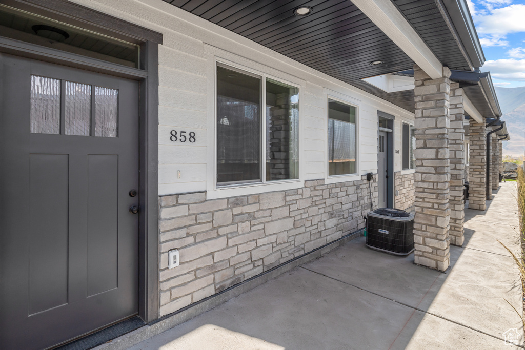 Entrance to property with central AC and stone siding