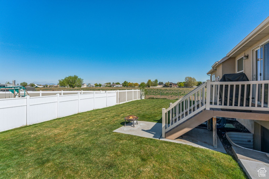 View of yard with an outdoor fire pit, a patio, a deck, and stairway