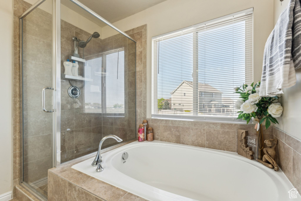 Bathroom featuring a stall shower and a bath