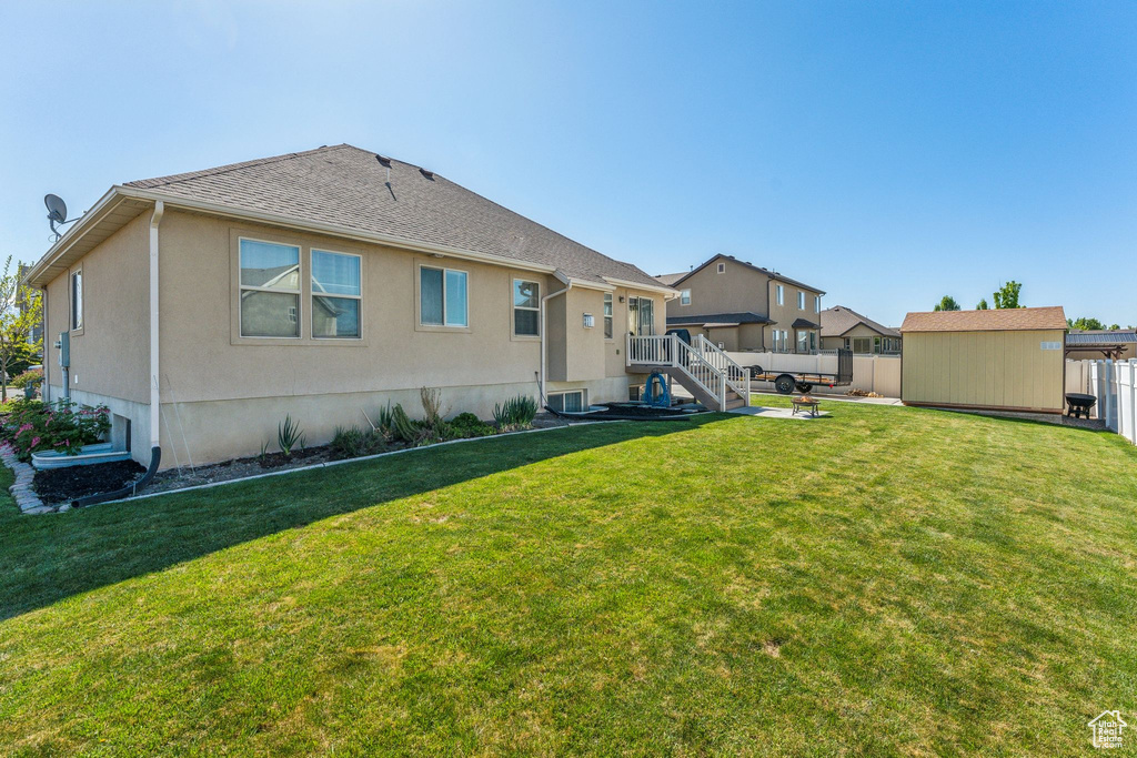 Rear view of property with an outdoor structure and stucco siding