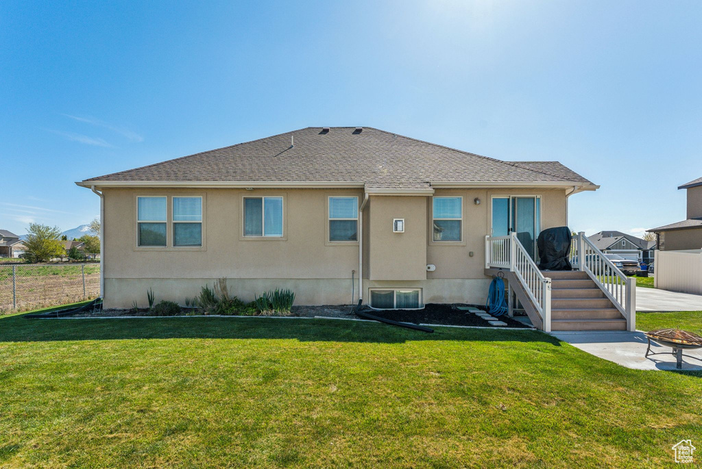 Rear view of property with stucco siding and roof with shingles