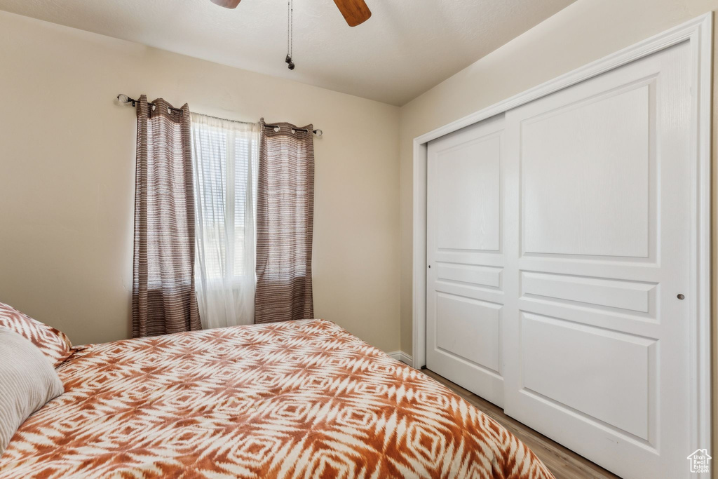 Bedroom featuring wood finished floors, a closet, and a ceiling fan