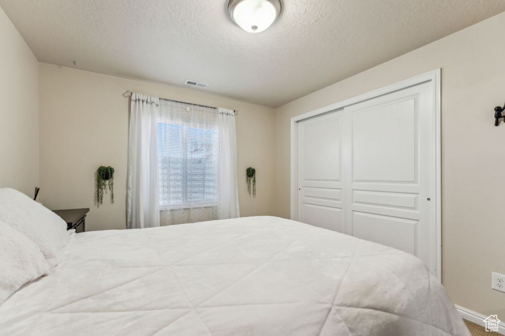 Bedroom with a closet and a textured ceiling