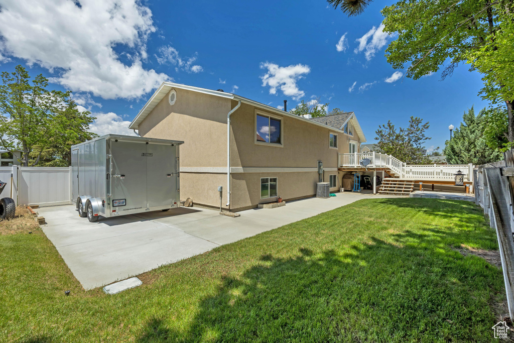 Back of property with stucco siding, a deck, a patio area, and stairway