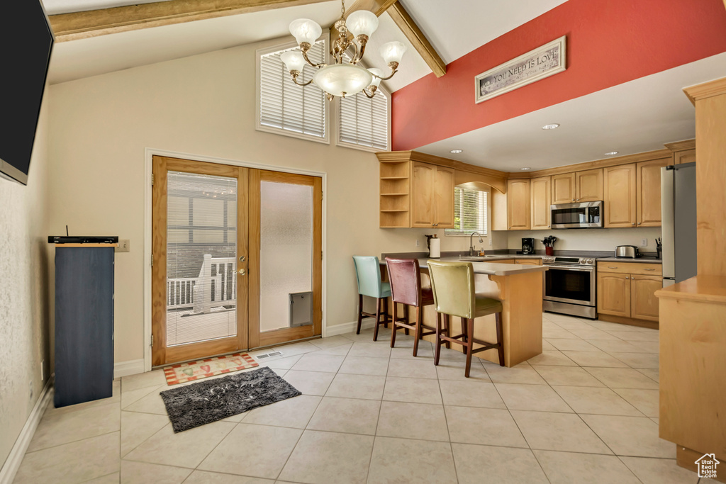 Kitchen with appliances with stainless steel finishes, a peninsula, open shelves, high vaulted ceiling, and a chandelier