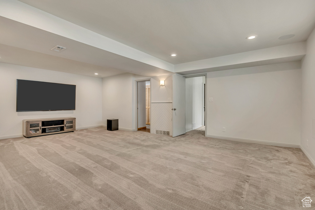 Unfurnished living room featuring light colored carpet, recessed lighting, and baseboards