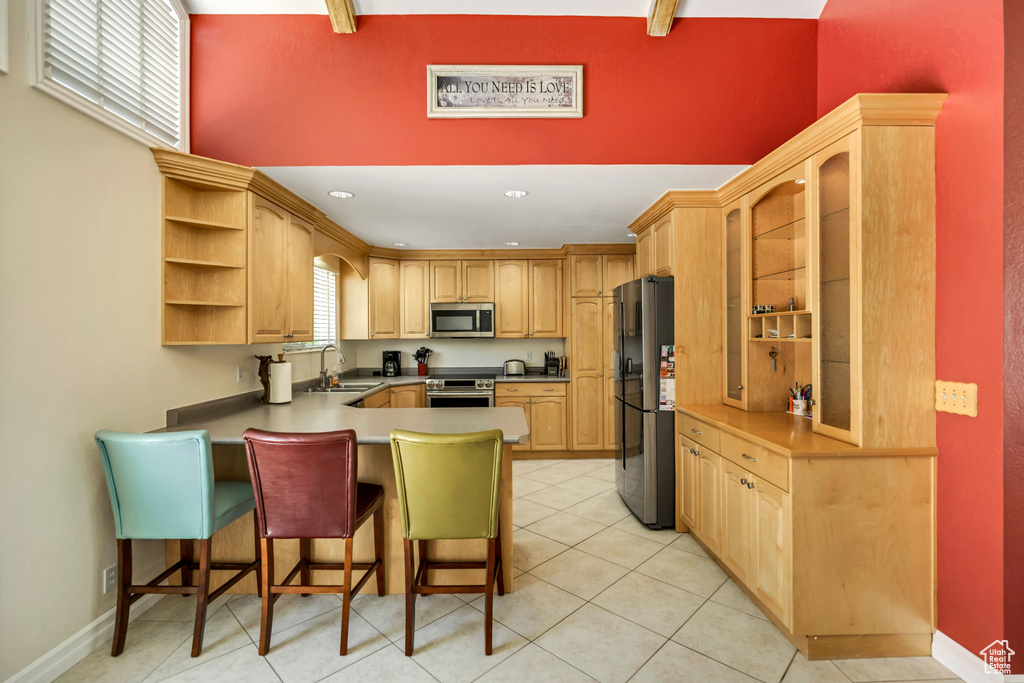 Kitchen with appliances with stainless steel finishes, a sink, open shelves, a peninsula, and a kitchen bar