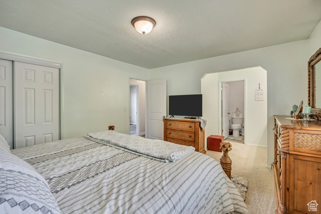 Carpeted bedroom featuring a closet