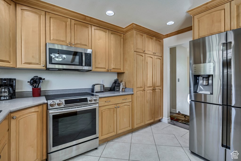 Kitchen with stainless steel appliances, light tile patterned floors, light countertops, and recessed lighting