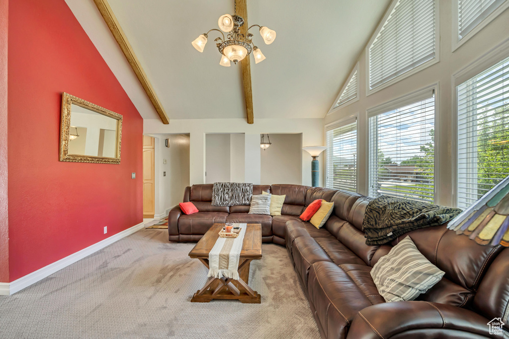 Carpeted living area featuring high vaulted ceiling, a chandelier, healthy amount of natural light, and baseboards