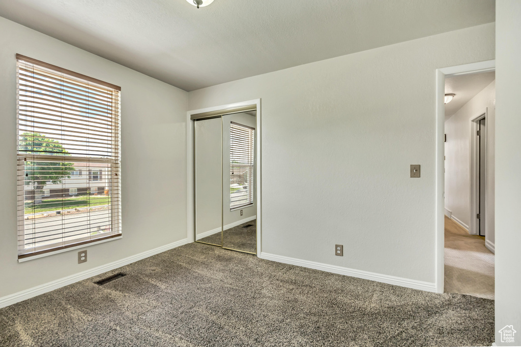 Unfurnished bedroom featuring carpet floors, a closet, and baseboards