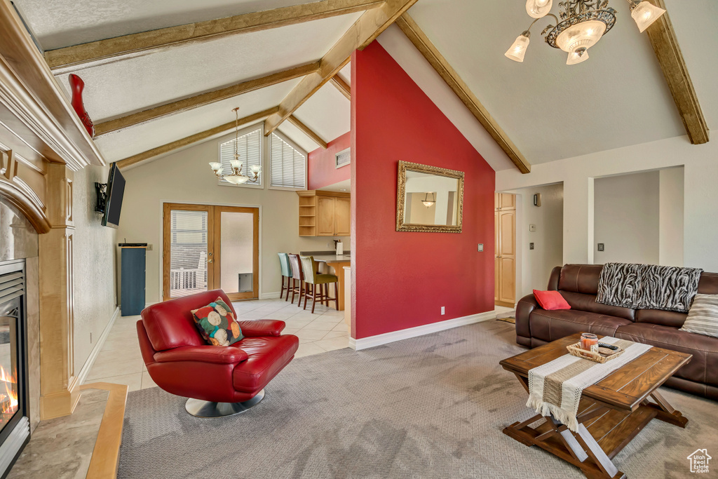 Living room with a chandelier, beam ceiling, a fireplace, light tile patterned floors, and baseboards