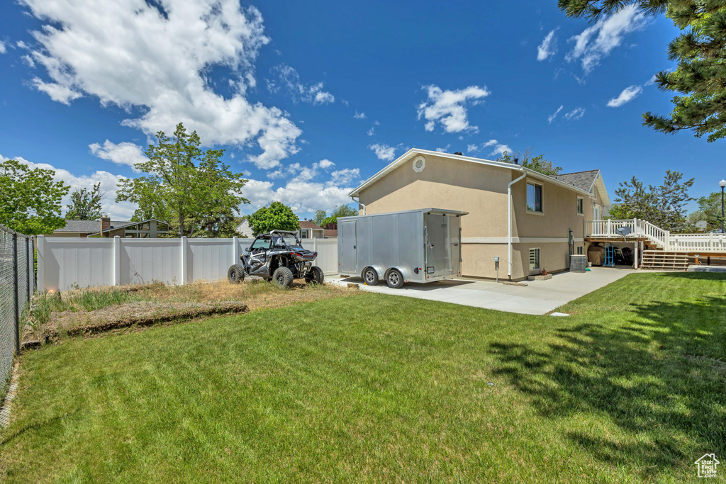 Rear view of house with stucco siding, a patio, and a wooden deck