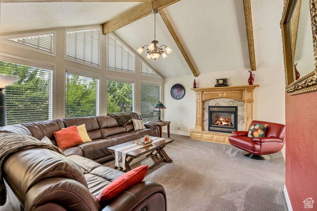 Living area featuring carpet flooring, a chandelier, beam ceiling, high vaulted ceiling, and a fireplace