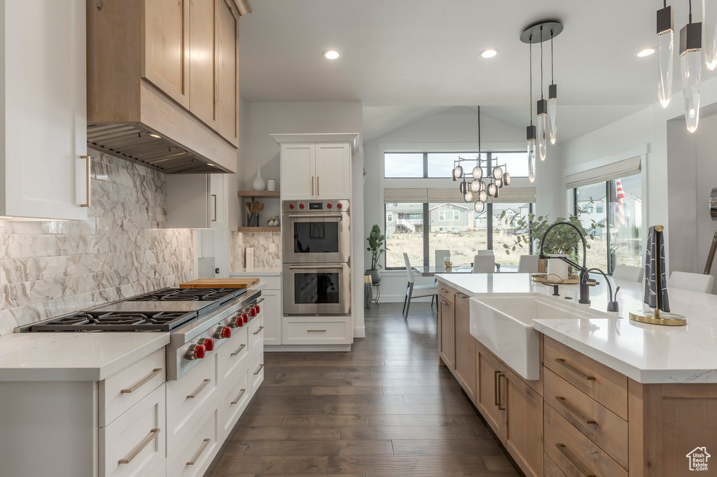 Kitchen with a sink, appliances with stainless steel finishes, custom exhaust hood, recessed lighting, and backsplash