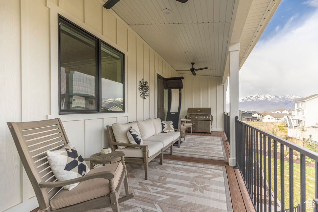 Balcony featuring a ceiling fan, a grill, a mountain view, and an outdoor living space
