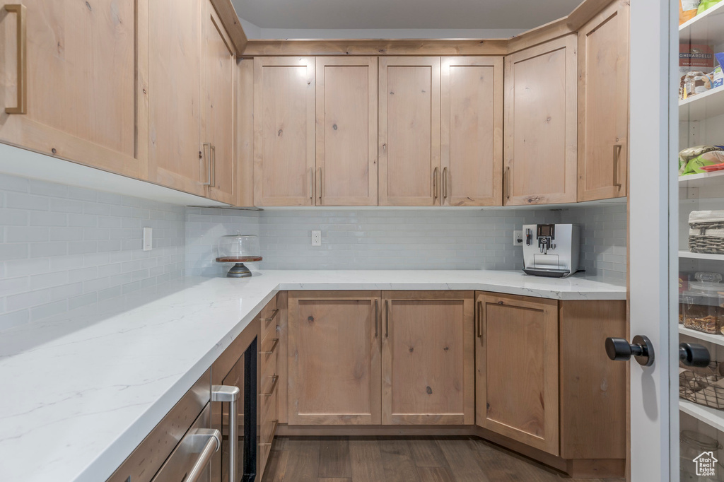 Kitchen featuring backsplash, dark wood-style flooring, and light brown cabinets
