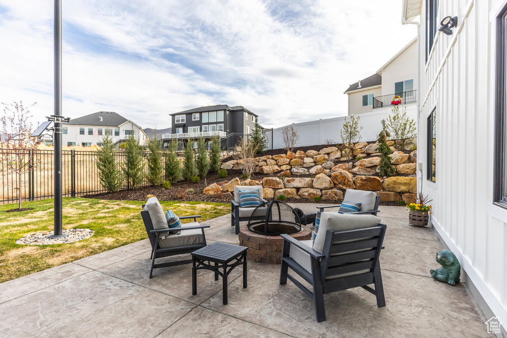 Fenced backyard with a fire pit, a patio area, and a residential view