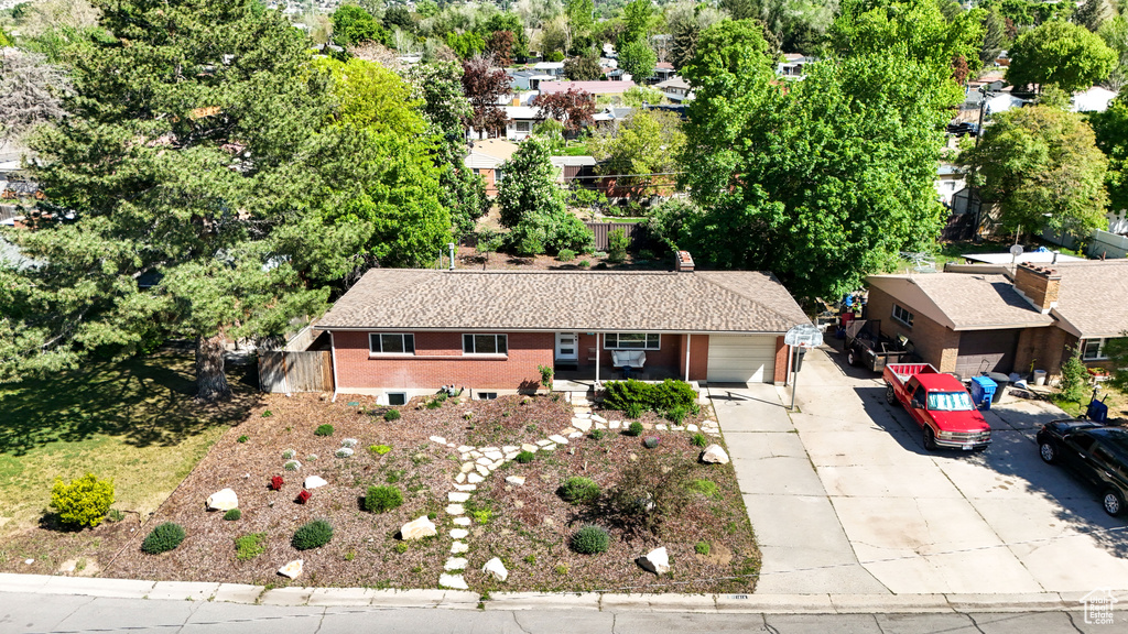Aerial view of property and surrounding area featuring a tree filled landscape