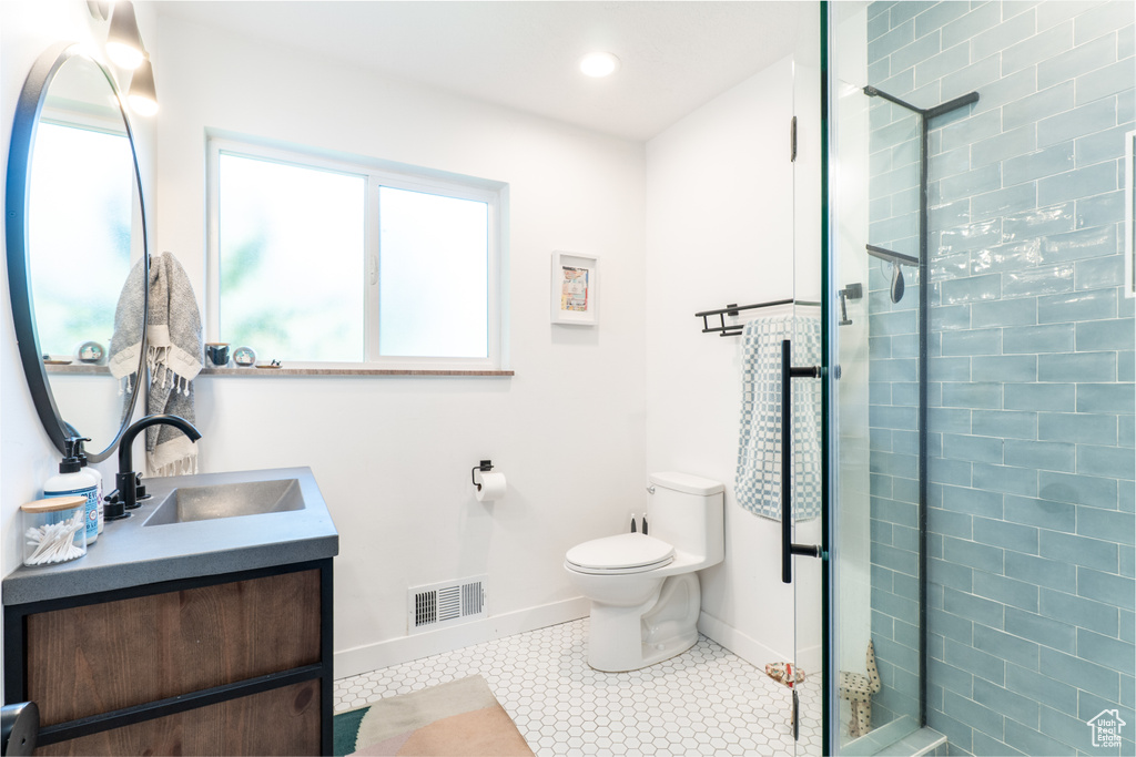 Full bath featuring healthy amount of natural light, a shower stall, toilet, baseboards, and recessed lighting