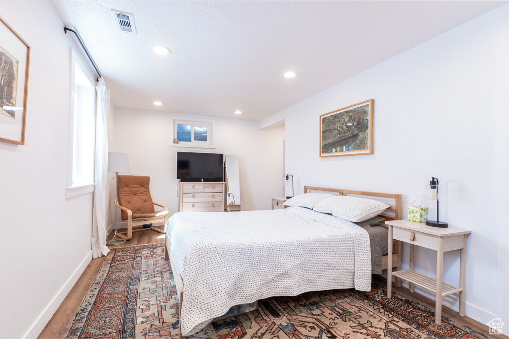 Bedroom with wood finished floors, recessed lighting, and baseboards