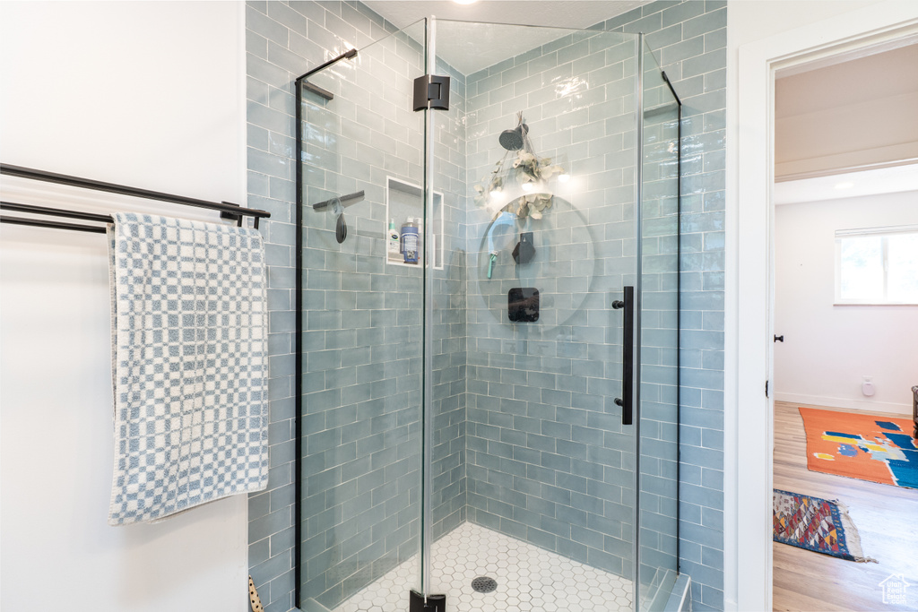 Full bath featuring a stall shower and wood finished floors