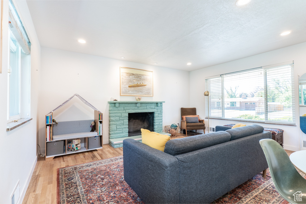 Living room featuring wood finished floors, recessed lighting, baseboards, and a fireplace