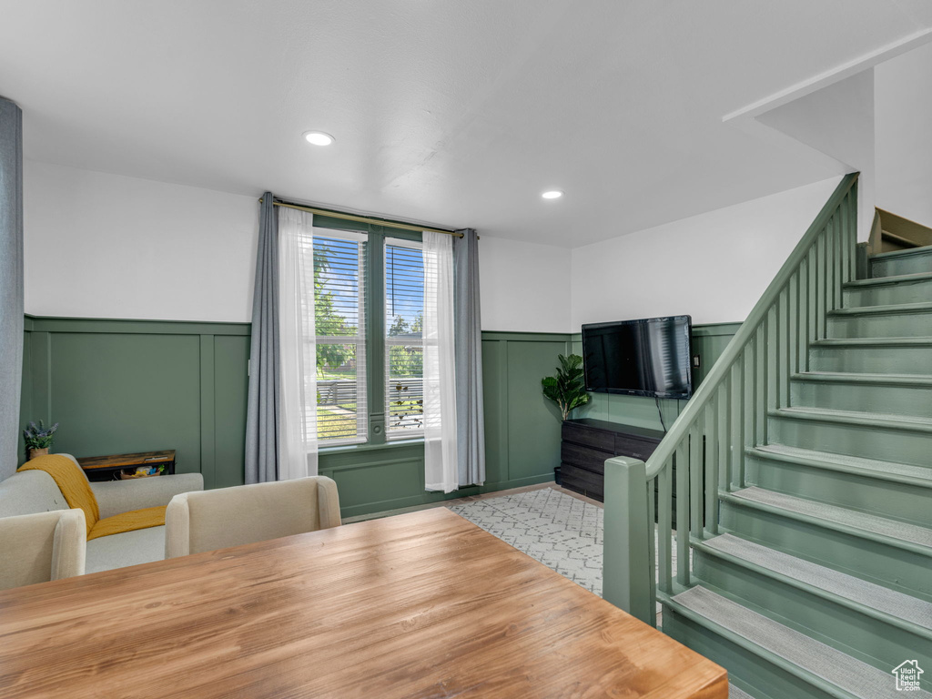 Dining room with stairway, a wainscoted wall, a decorative wall, and recessed lighting