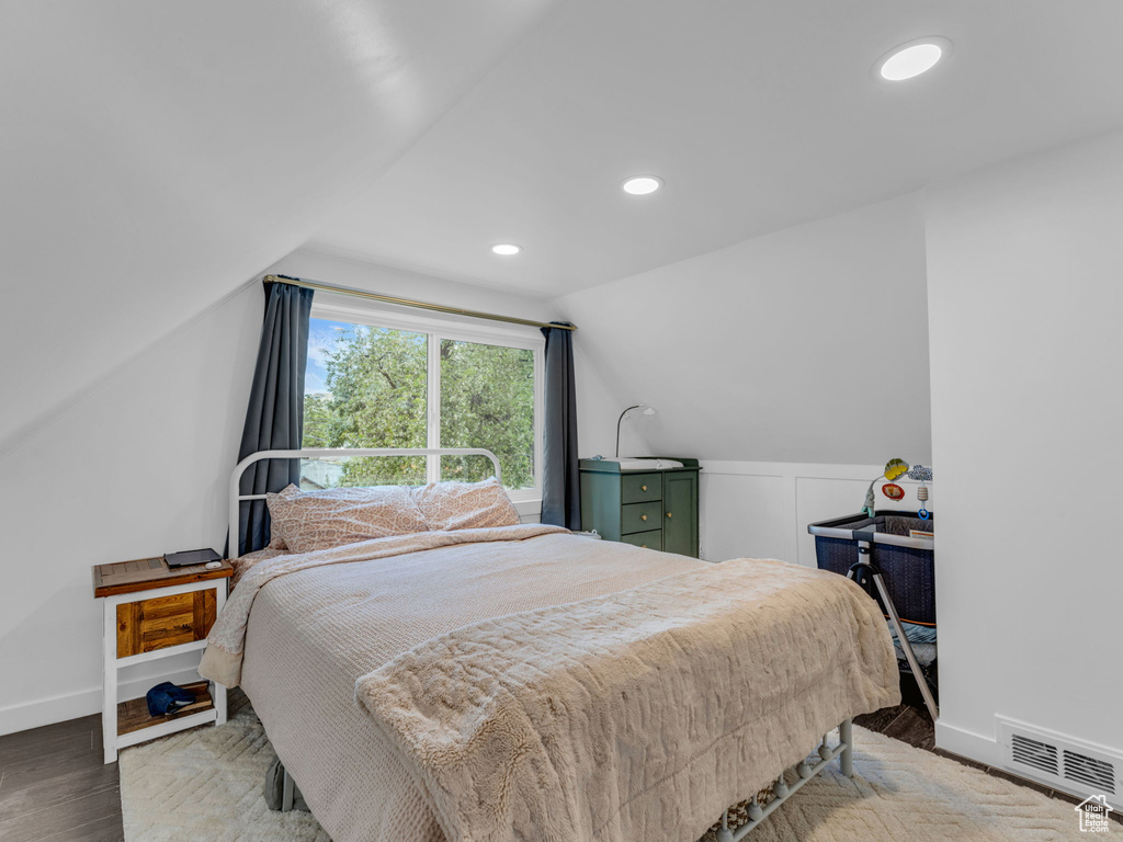 Bedroom featuring vaulted ceiling, wood finished floors, baseboards, and recessed lighting