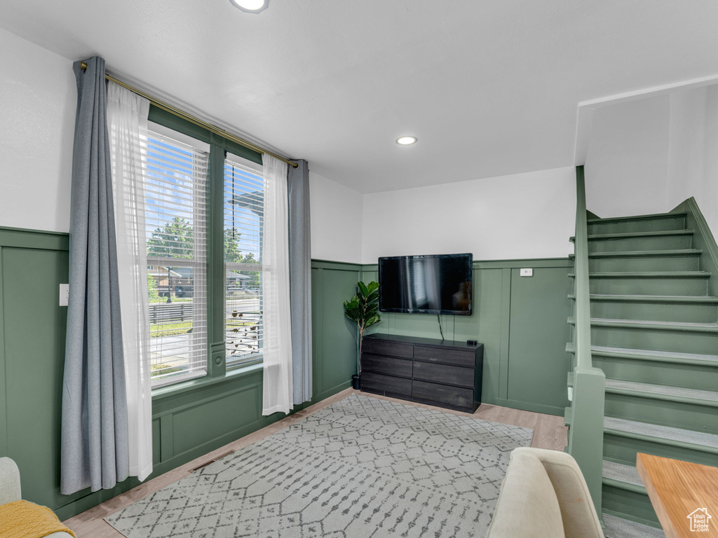 Bedroom with multiple windows, wainscoting, recessed lighting, a decorative wall, and light wood-type flooring